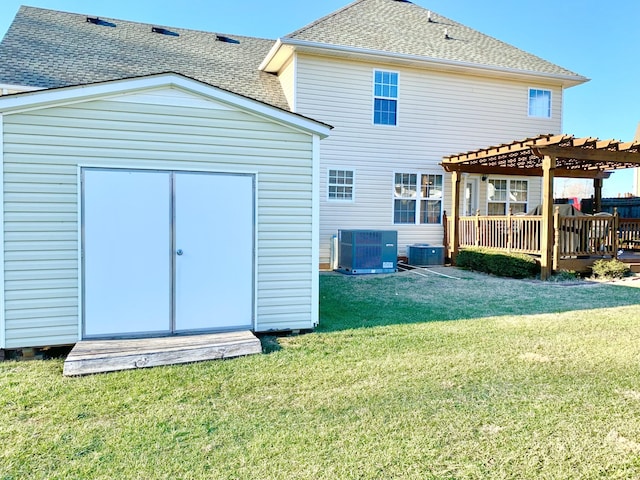 back of house featuring a pergola, a lawn, and a storage unit