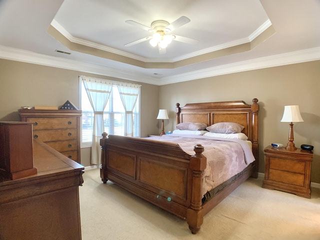 carpeted bedroom with a raised ceiling, ceiling fan, and crown molding