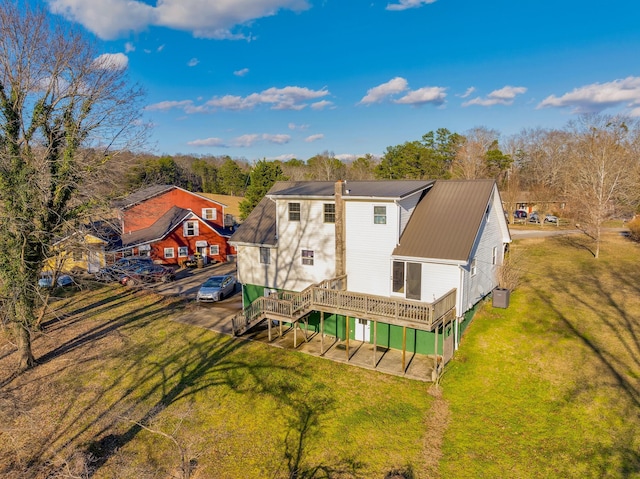 rear view of house featuring a lawn and a wooden deck