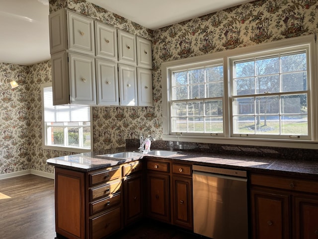 kitchen with dark hardwood / wood-style flooring, dishwasher, kitchen peninsula, and sink