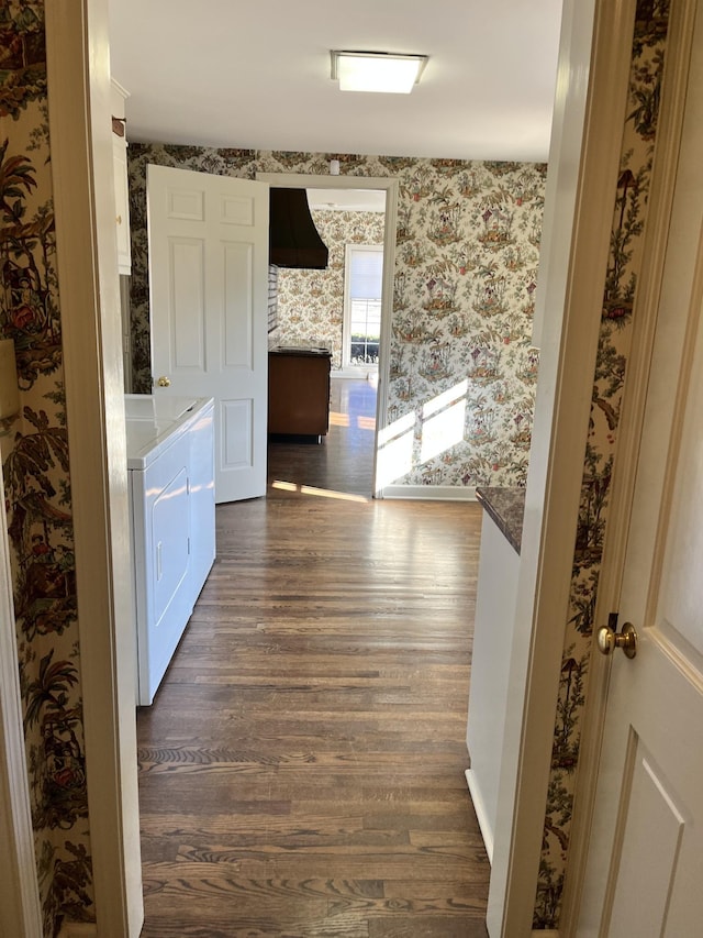 corridor featuring dark wood-type flooring and separate washer and dryer