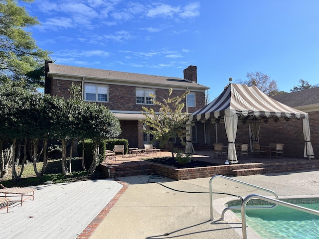 rear view of property featuring a gazebo and a patio area