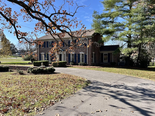 colonial inspired home with a front lawn