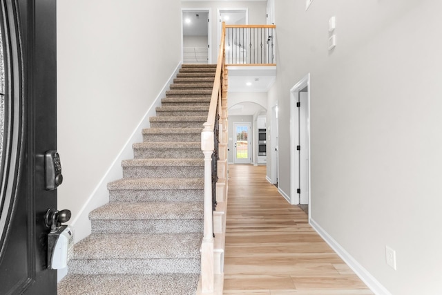 stairs with a high ceiling and wood-type flooring