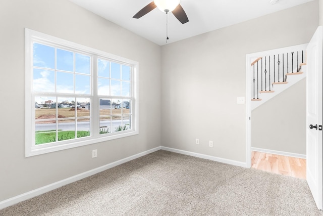 unfurnished room with ceiling fan and carpet