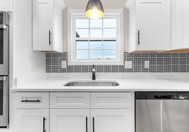 kitchen featuring appliances with stainless steel finishes, white cabinets, and sink