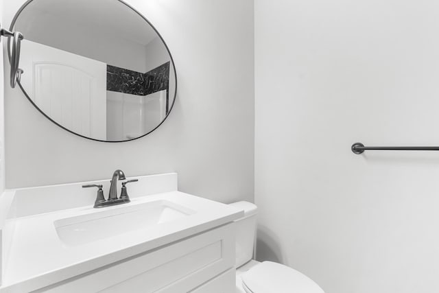 bathroom featuring a shower, toilet, and vanity