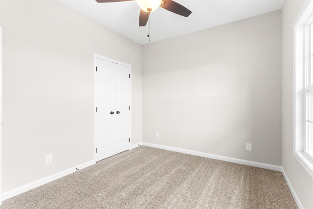 carpeted spare room with ceiling fan