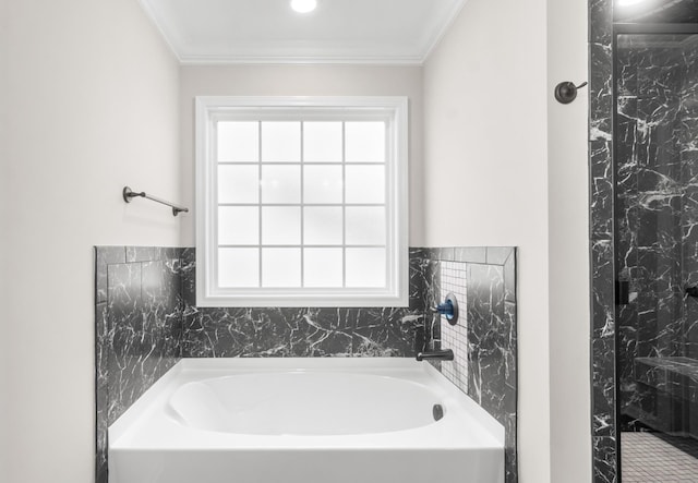 bathroom featuring ornamental molding and a tub