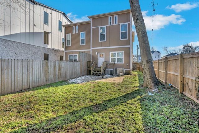 back of property featuring cooling unit and a lawn