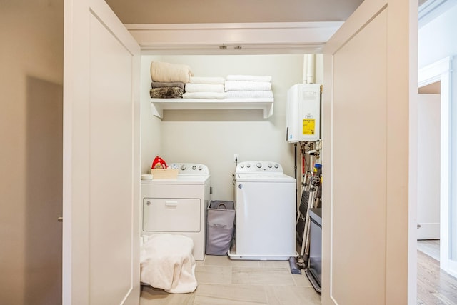 laundry room with separate washer and dryer and water heater