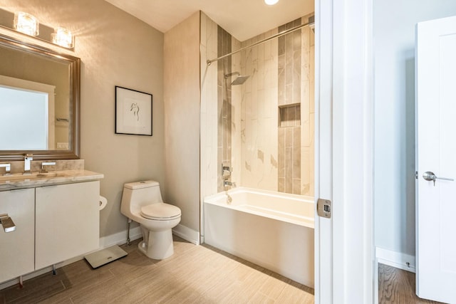 full bathroom featuring toilet, tiled shower / bath, and vanity