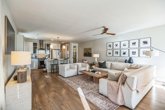 living room with ceiling fan and dark hardwood / wood-style floors