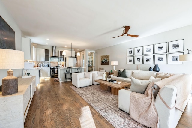 living room featuring ceiling fan and dark hardwood / wood-style floors