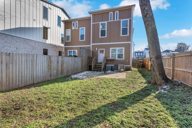 back of house with central AC unit and a yard