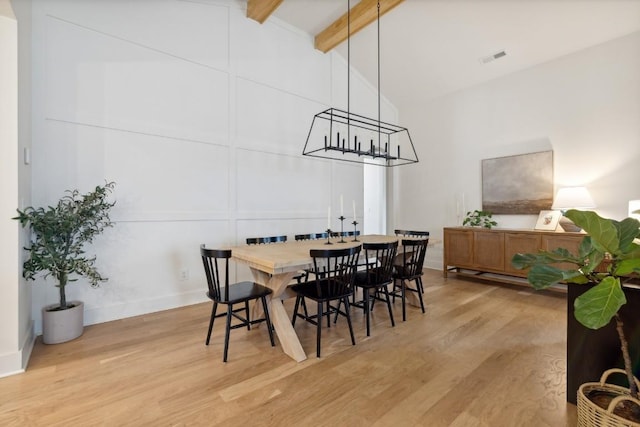 dining space with light hardwood / wood-style floors, high vaulted ceiling, and beamed ceiling