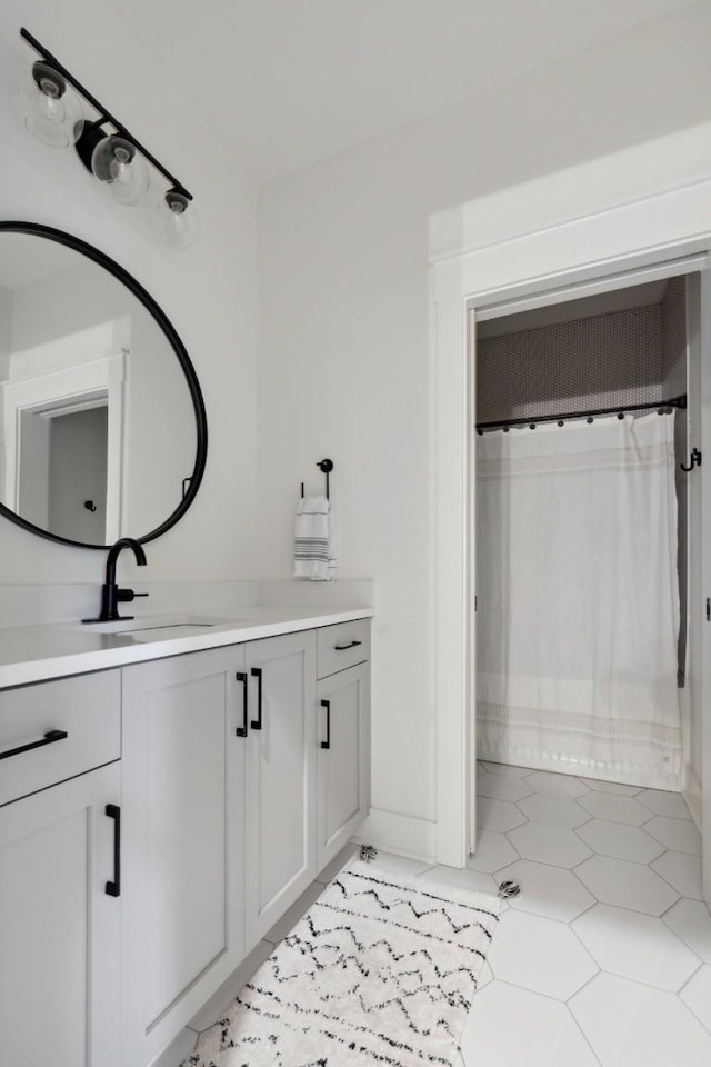 bathroom with tile patterned floors, walk in shower, and vanity