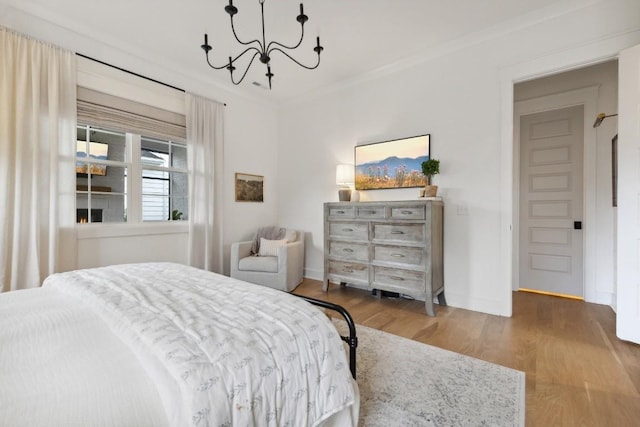 bedroom with an inviting chandelier, ornamental molding, and hardwood / wood-style floors