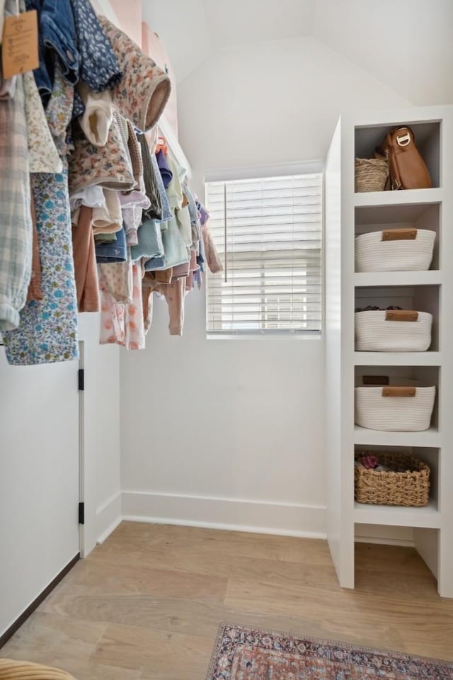 spacious closet featuring lofted ceiling and light hardwood / wood-style flooring