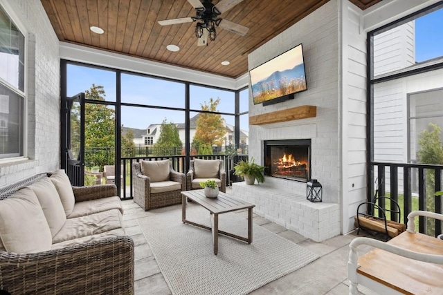 sunroom / solarium with ceiling fan, wood ceiling, and an outdoor brick fireplace