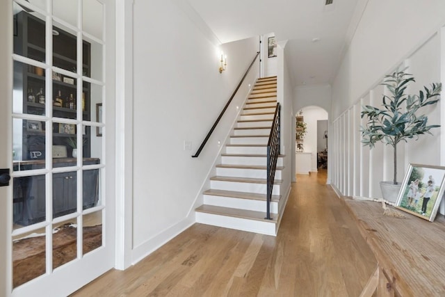 stairway featuring crown molding and hardwood / wood-style floors