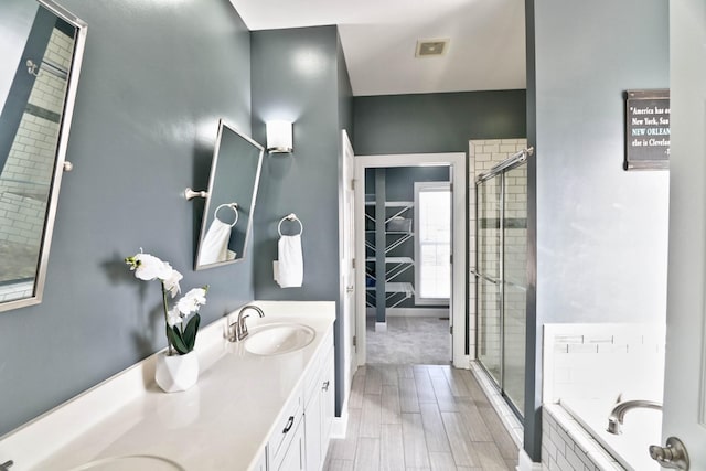 bathroom featuring shower with separate bathtub, wood-type flooring, and vanity