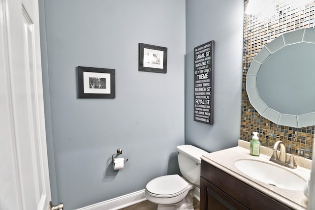 bathroom with tasteful backsplash, vanity, and toilet