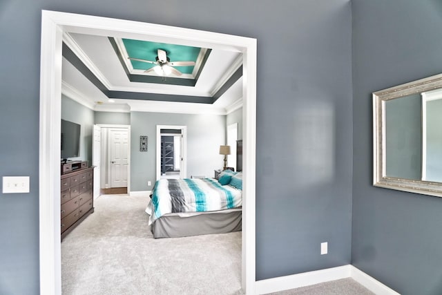 bedroom featuring carpet, ornamental molding, and a raised ceiling