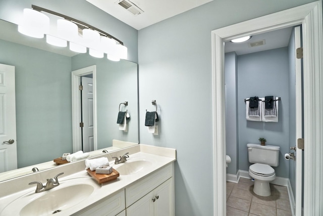 bathroom featuring toilet, vanity, and tile patterned flooring