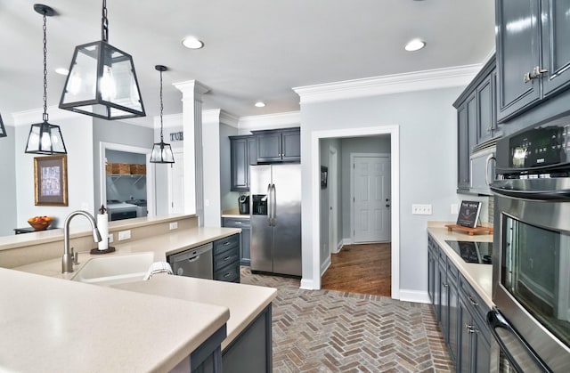 kitchen featuring crown molding, stainless steel appliances, sink, and decorative light fixtures