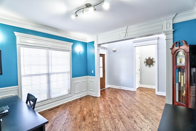 office space featuring dark hardwood / wood-style flooring, crown molding, and ornate columns