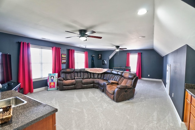 carpeted living room featuring lofted ceiling, ceiling fan, and sink