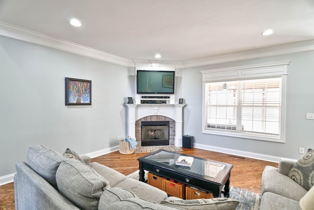 living room featuring a brick fireplace, crown molding, and hardwood / wood-style floors