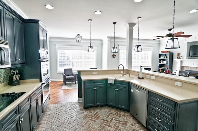 kitchen featuring ceiling fan, pendant lighting, sink, appliances with stainless steel finishes, and ornamental molding