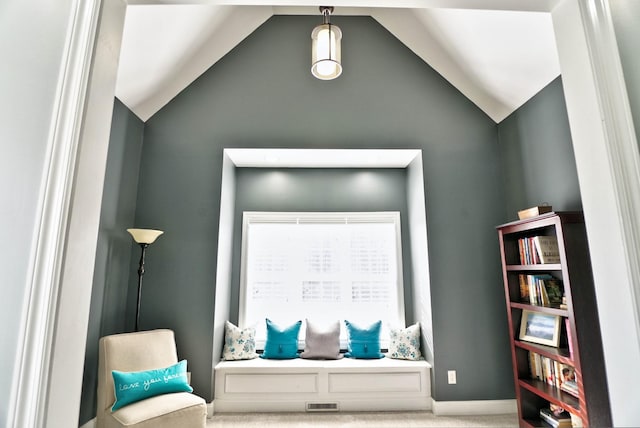 living area featuring lofted ceiling and light colored carpet