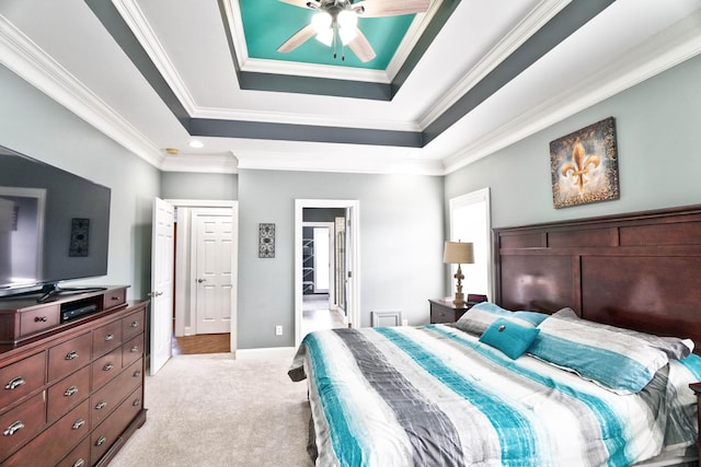 carpeted bedroom featuring ceiling fan, a tray ceiling, and crown molding