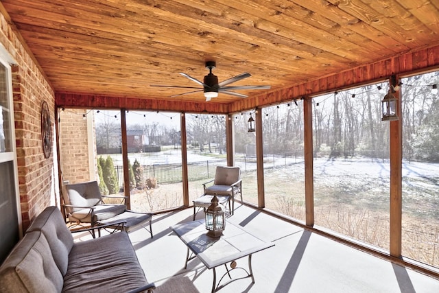 unfurnished sunroom with ceiling fan, wood ceiling, and plenty of natural light