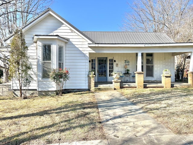 bungalow-style house featuring covered porch and a front yard