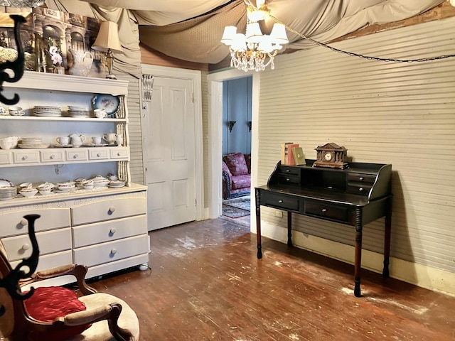 sitting room with dark wood-type flooring and an inviting chandelier