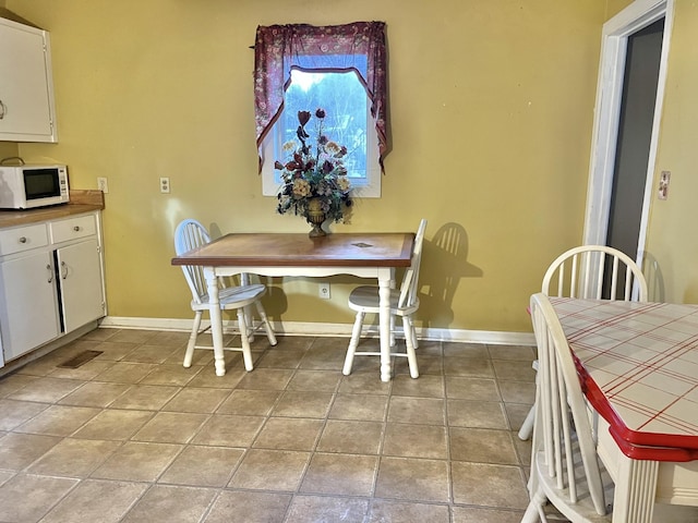 dining space featuring light tile patterned flooring