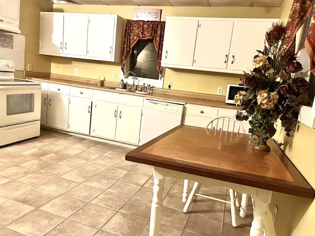 kitchen featuring light tile patterned floors, white cabinetry, sink, and white appliances