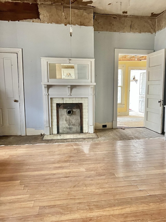 miscellaneous room featuring light hardwood / wood-style floors and a brick fireplace