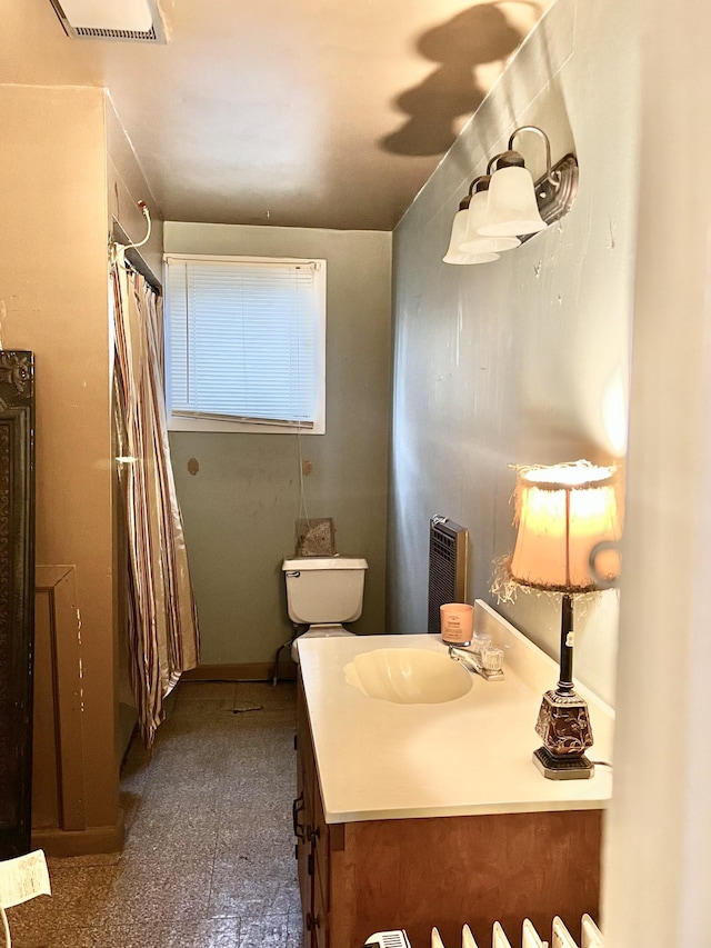 bathroom with toilet, vanity, and a shower with shower curtain