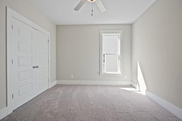 empty room featuring ceiling fan and carpet flooring