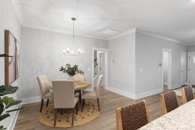 dining space featuring hardwood / wood-style floors, crown molding, and an inviting chandelier