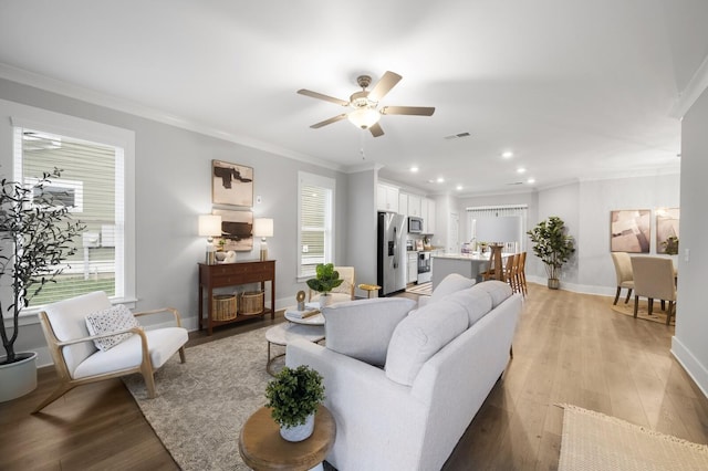 living room with ceiling fan, light hardwood / wood-style flooring, and ornamental molding