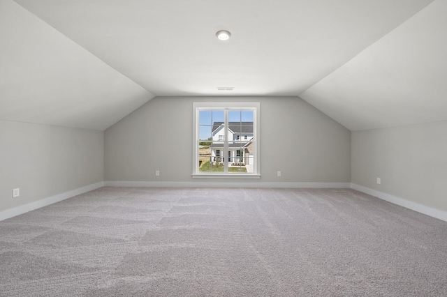 bonus room featuring lofted ceiling and light carpet