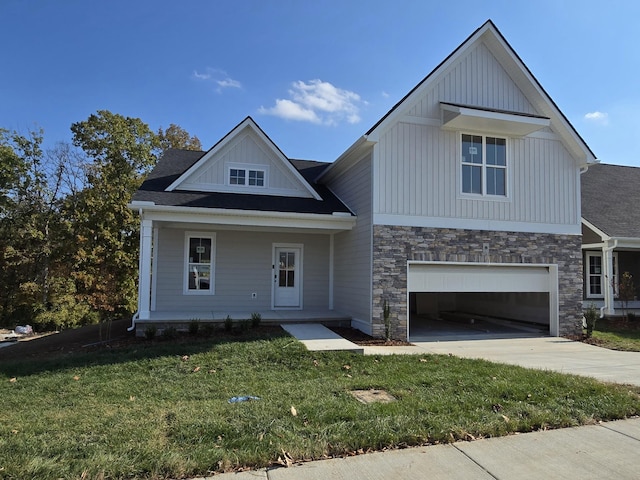 view of front of house featuring a front lawn, a garage, and a porch