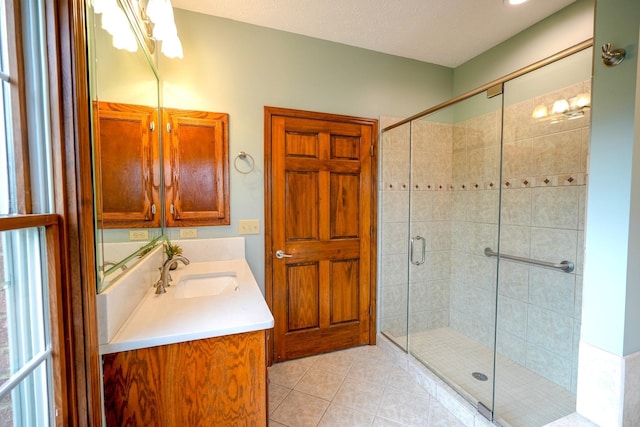 bathroom featuring tile patterned floors, vanity, and a shower with shower door