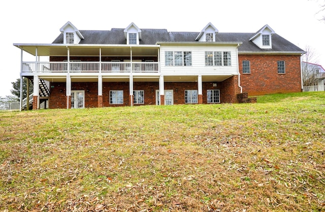 rear view of property with a deck and a yard